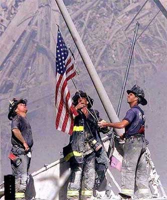 Firemen raising flag among Sept 11 rubble.